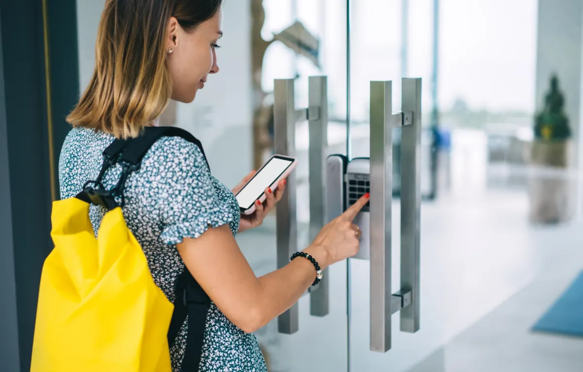 Traveler pulling a suitcase through a hotel lobby toward reception